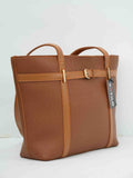 Brown textured leather tote bag with gold hardware and dual handles on a white background