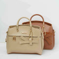 Beige and brown handbags with gold chain handles and bow accents on a white background